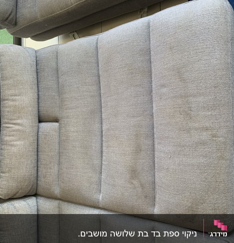 כרית ספה אפורה על יריעת בד כחולה